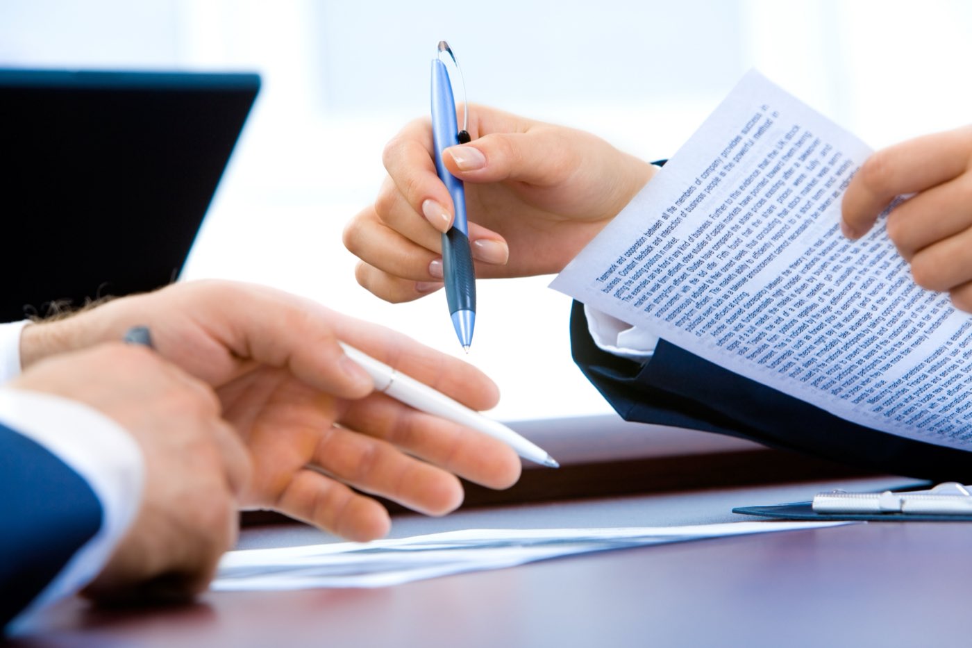Two people reviewing and signing a quotation document across a desk